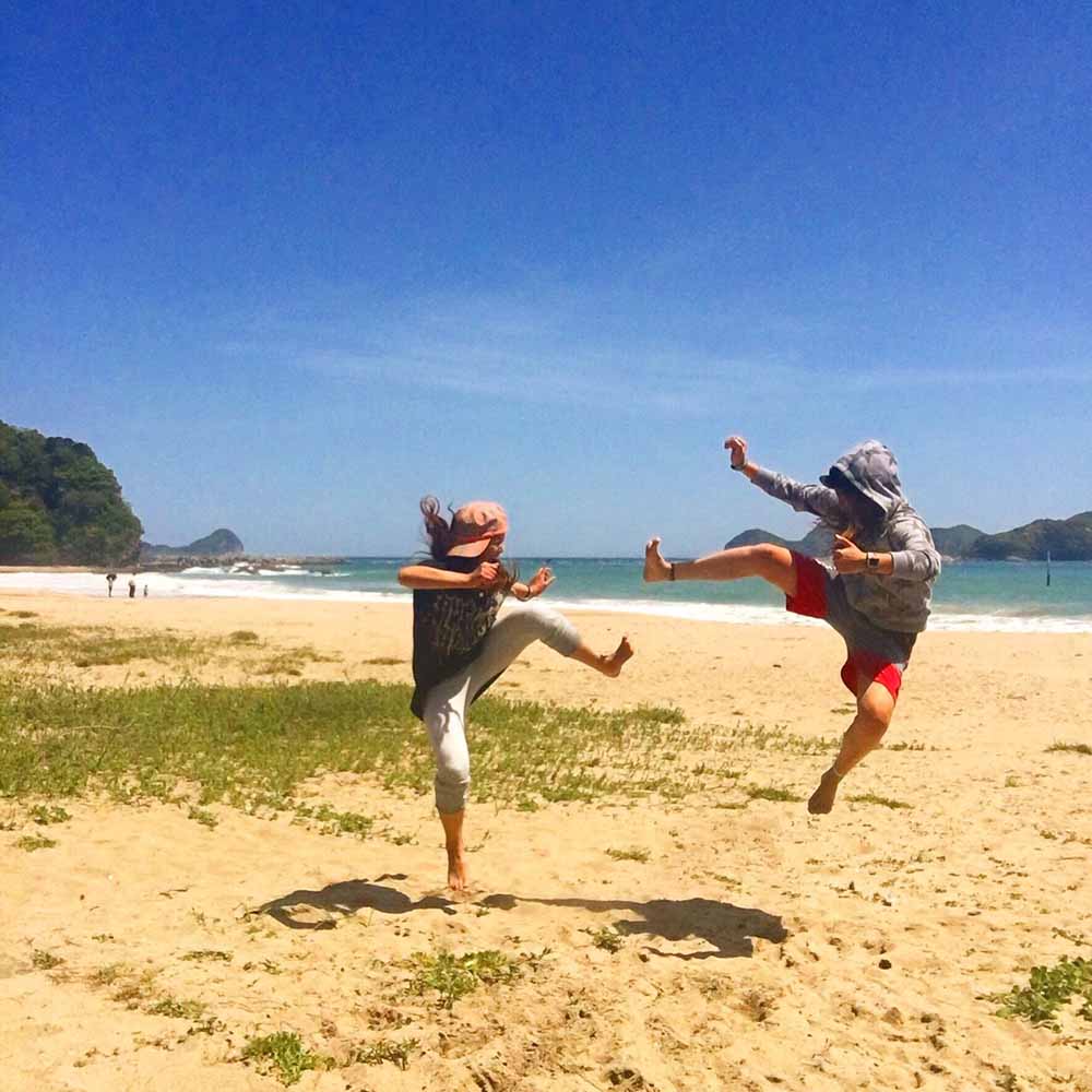 浜辺で飛び蹴りしあう２人