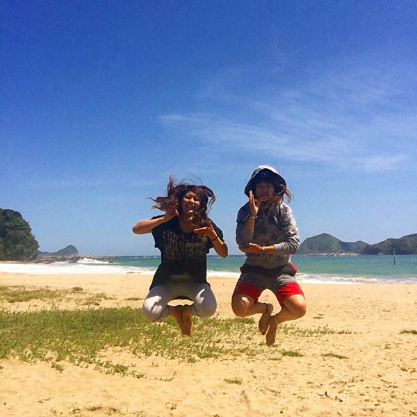 浜辺でジャンプする2人の女の子